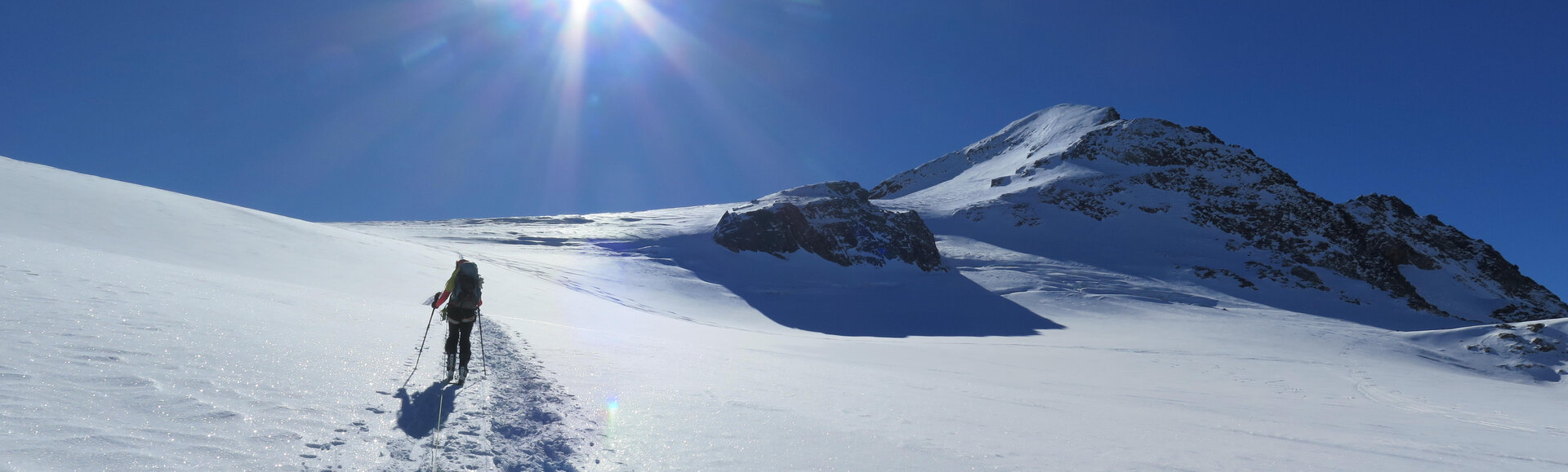 Person beim SkiBergsteigen im Sonnenlicht am Gipfelhang | © Peter Wohlhüter