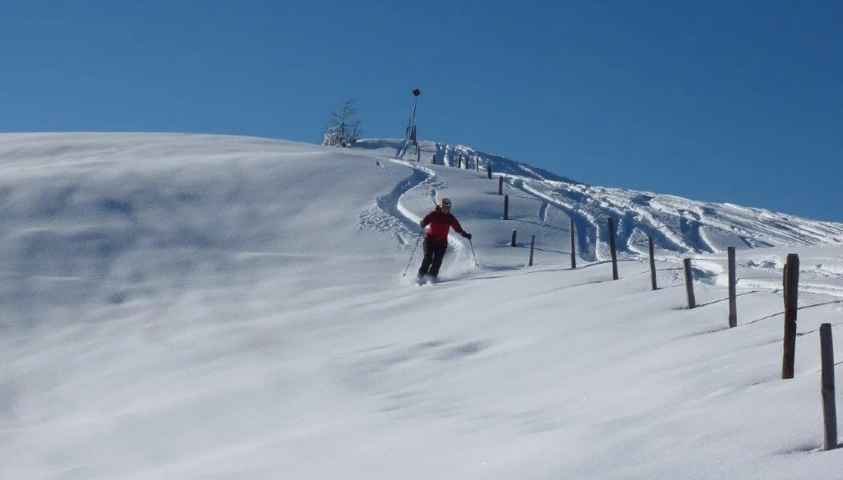 Eine Teilnehmerin der SkiAlpinfahrten der DAV Sektion Augsburg fährt im Tiefschnee Ski. | © Hartmut Seelus