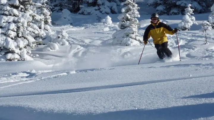 Ein Teilnehmer der SkiAlpinFahrten der DAV Sektion Augsburg fährt mit Skiern im Tiefschnee. | © Hartmut Seelus
