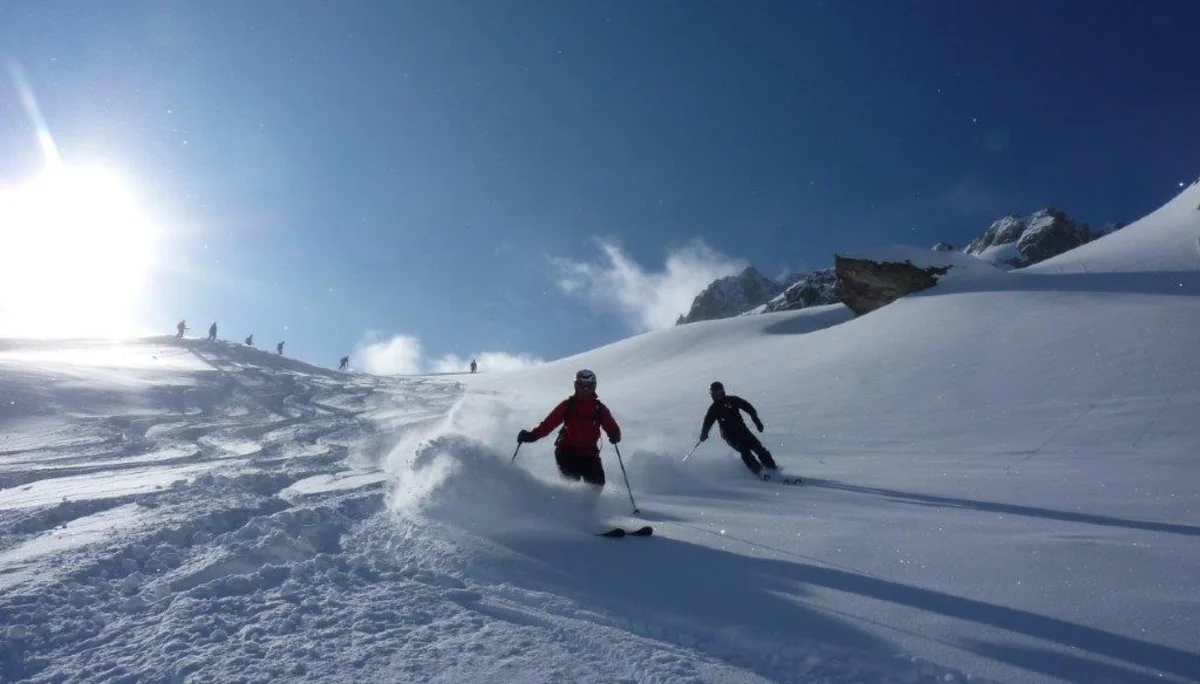 Zwei Teilnehmende der SkiAlpinfahrten der DAV Sektion Augsburg fahren im Tiefschnee die Piste herunter. | © Hartmut Seelus