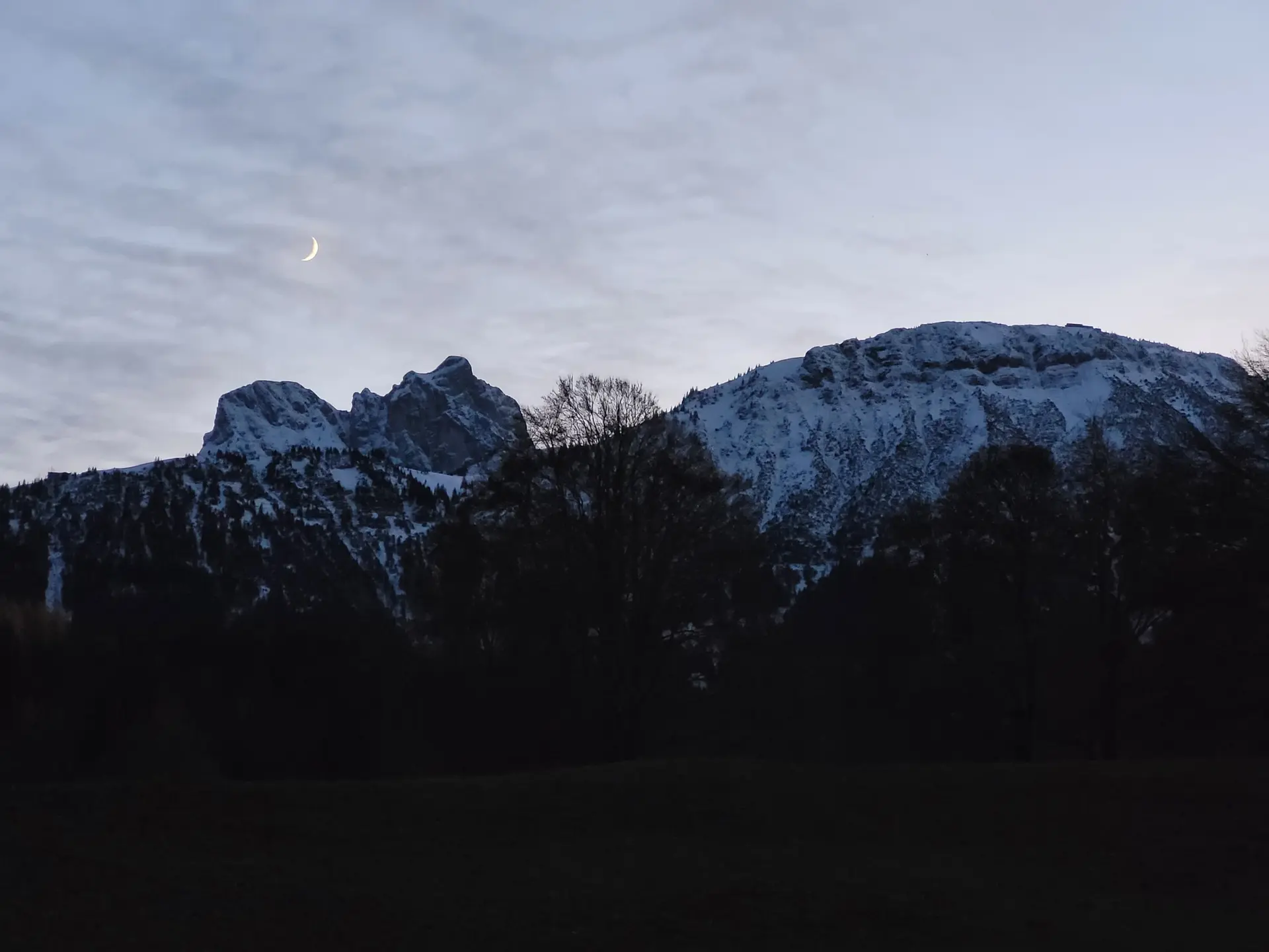 Blick auf schneebedeckte Berge mit Mondsichel | © Aron Nuber