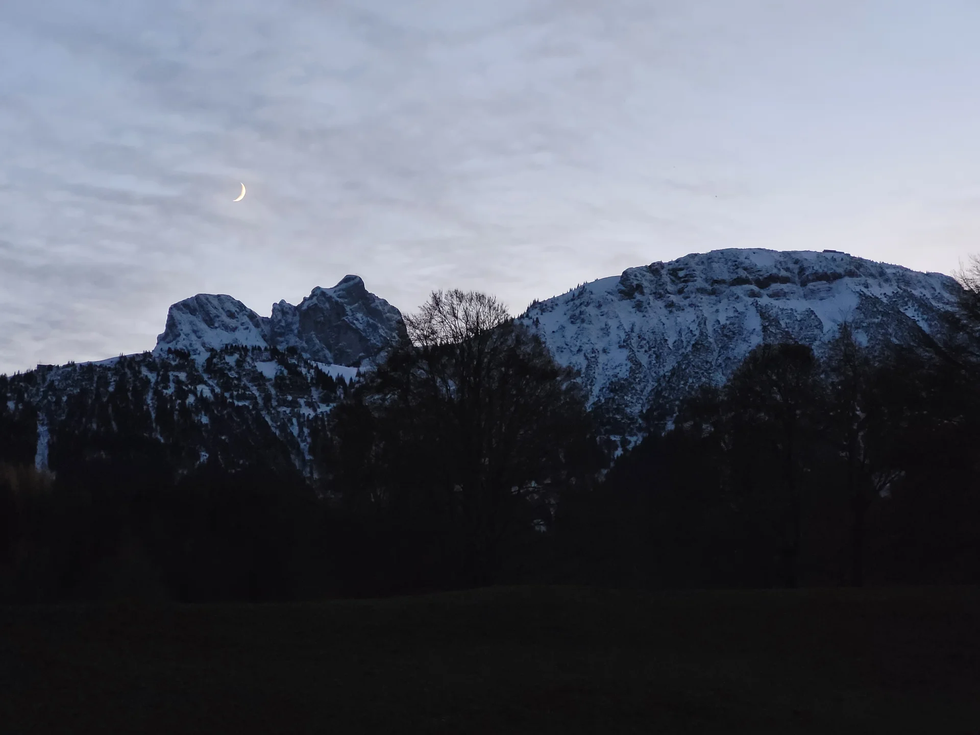 Blick auf schneebedeckte Berge mit Mondsichel | © Aron Nuber