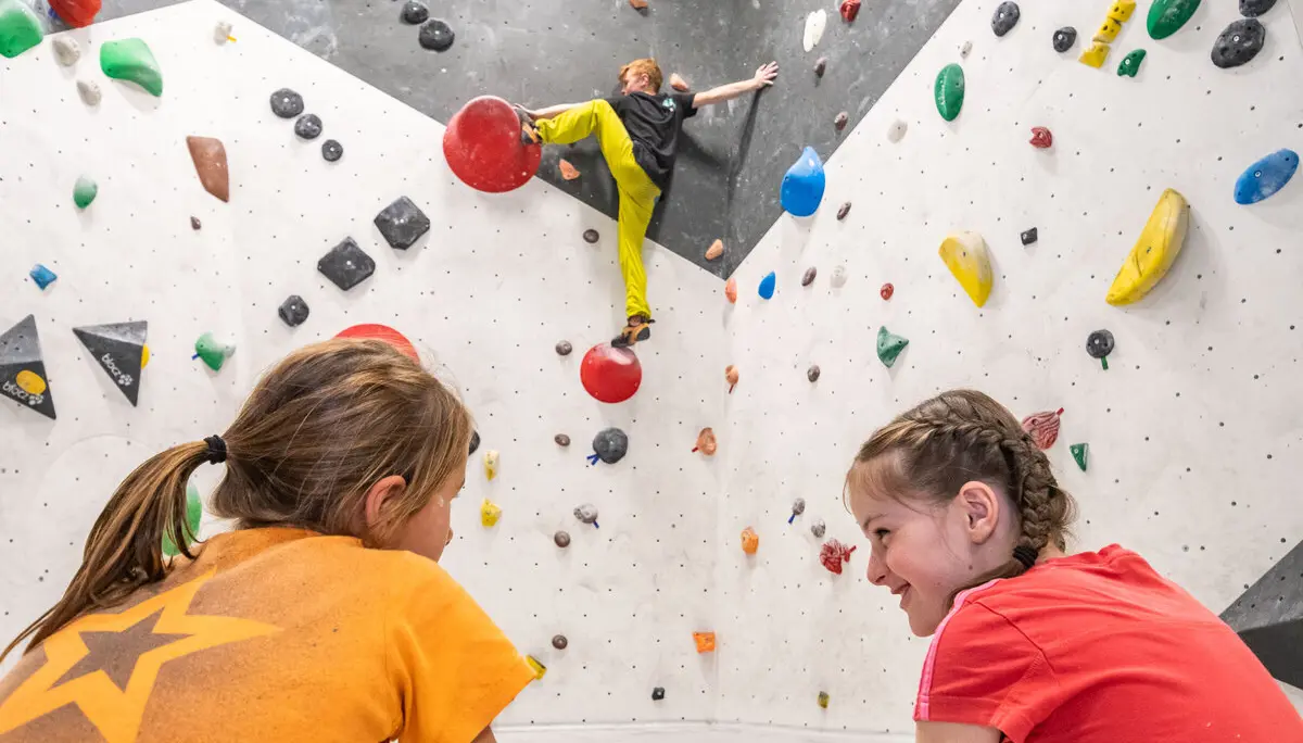 Im DAV Kletterzentrum Augsburg trainiert der Bouldernachwuchs für die nächsten anstehenden Wettkämpfe. Im Vordergrund sind zwei Mädchen aus der Leistungsportgruppe zu sehen. Im Hintergrund bouldert Max Dinger. | © Eckart Matthäus