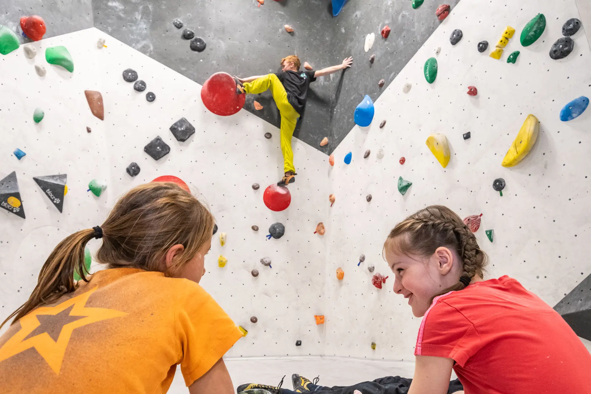 Im DAV Kletterzentrum Augsburg trainiert der Bouldernachwuchs für die nächsten anstehenden Wettkämpfe. Im Vordergrund sind zwei Mädchen aus der Leistungsportgruppe zu sehen. Im Hintergrund bouldert Max Dinger. | © Eckart Matthäus