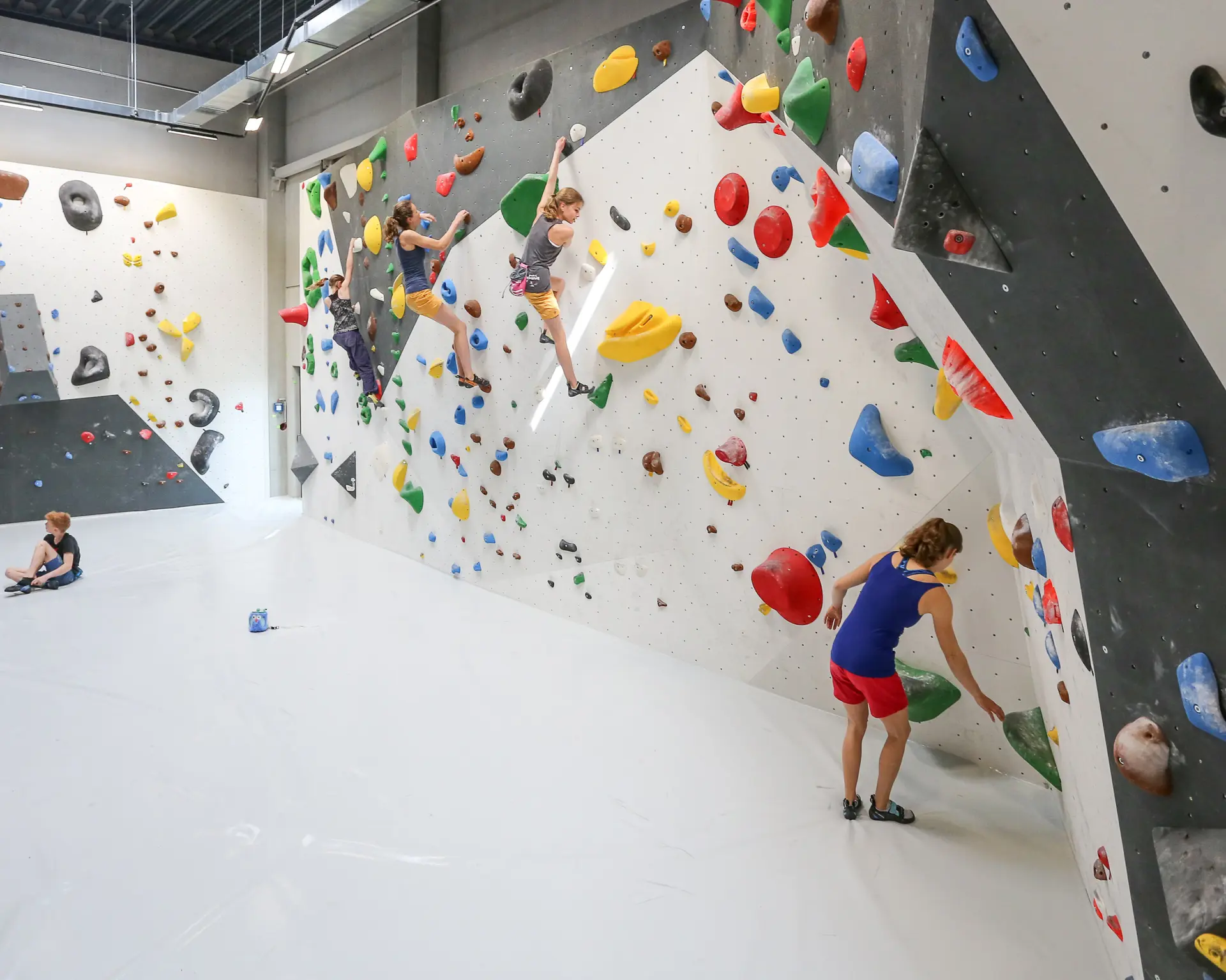 Mehrere Kinder üben im Boulderbereich des DAV Kletterzentrum Augsburg der DAV Sektion Augsburg. | © Thorsten Franzisi