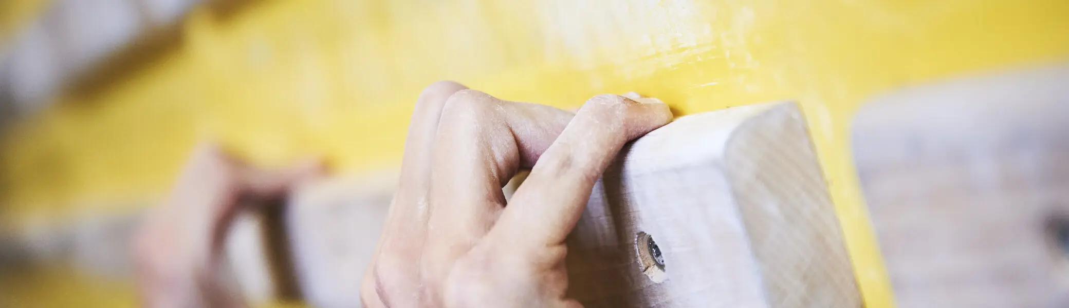 Hände greifen nach Holzelementen an einer Kletterwand | © DAV/Frank Kretschmann