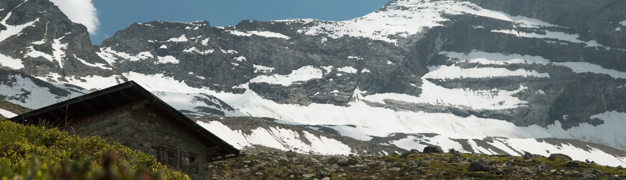 Schneebedeckte Berge, eine Hütte im Vordergrund | © DAV/Marcel Dambon